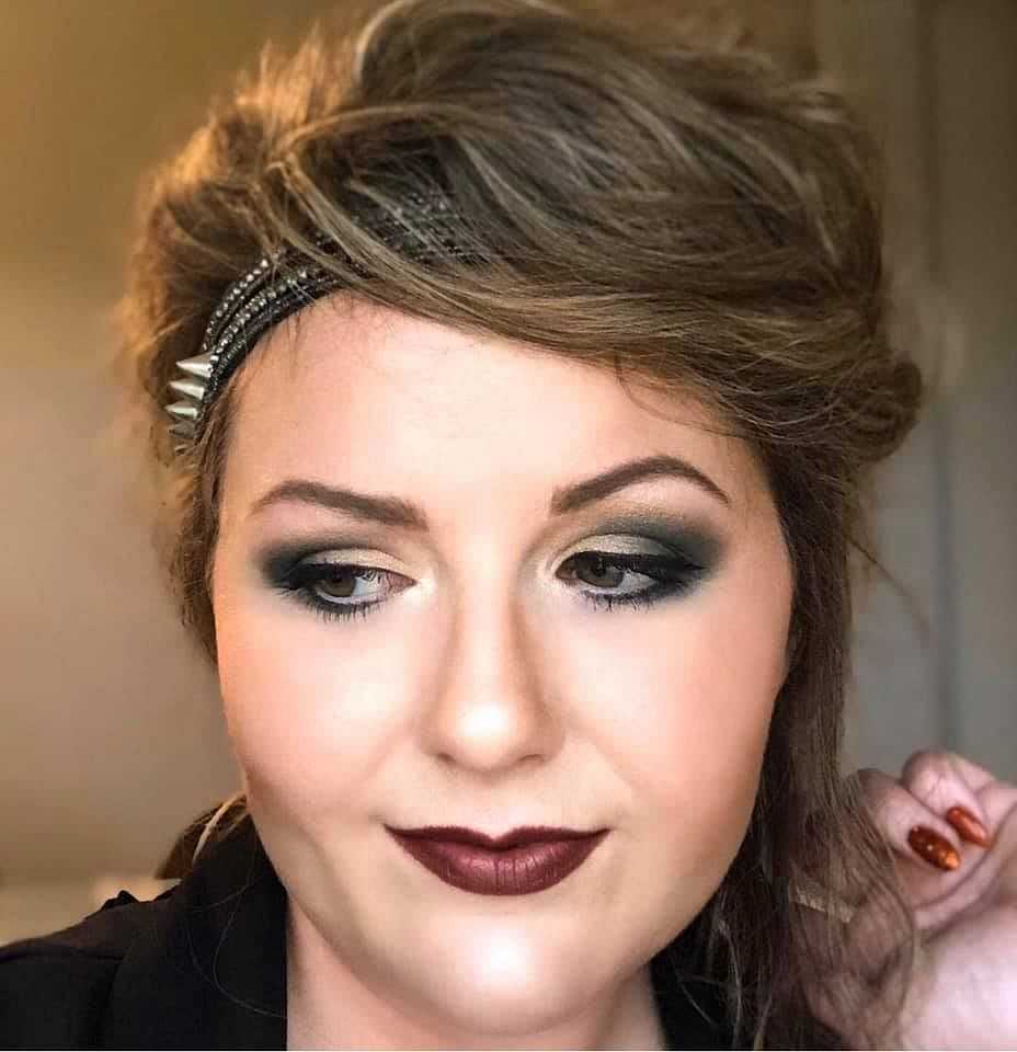 Woman with smoky eye makeup and dark lipstick.