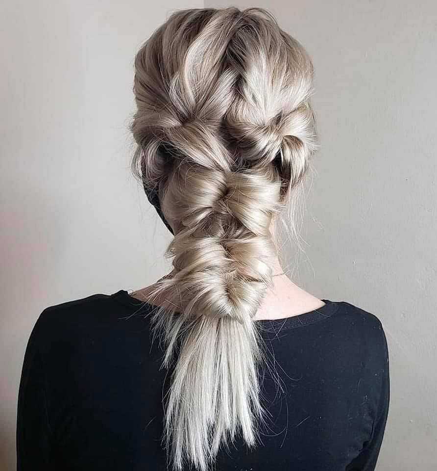 Blonde hair styled in an intricate fishtail braid, seen from the back against a neutral background.